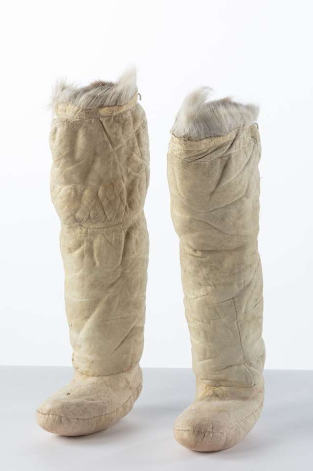 Deux bottes longues en cuir, de couleur beige, avec une bordure en fourrure blanche sur le haut.